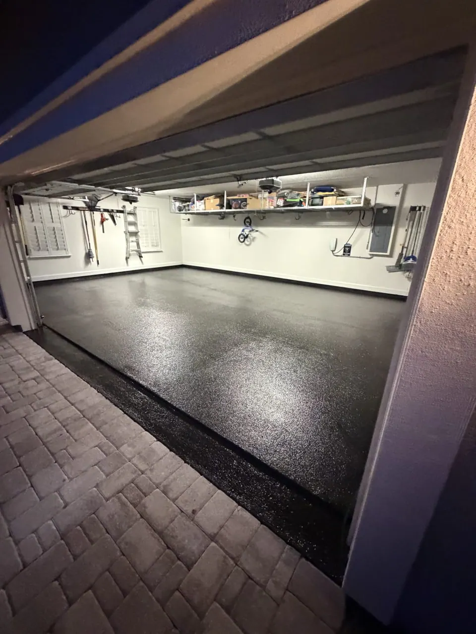 Dark flake garage floor viewed from the driveway at night