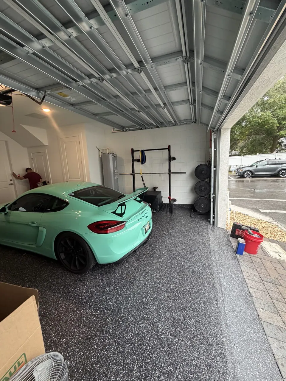 Dark flake garage floor coating beneath a mint-green sports car