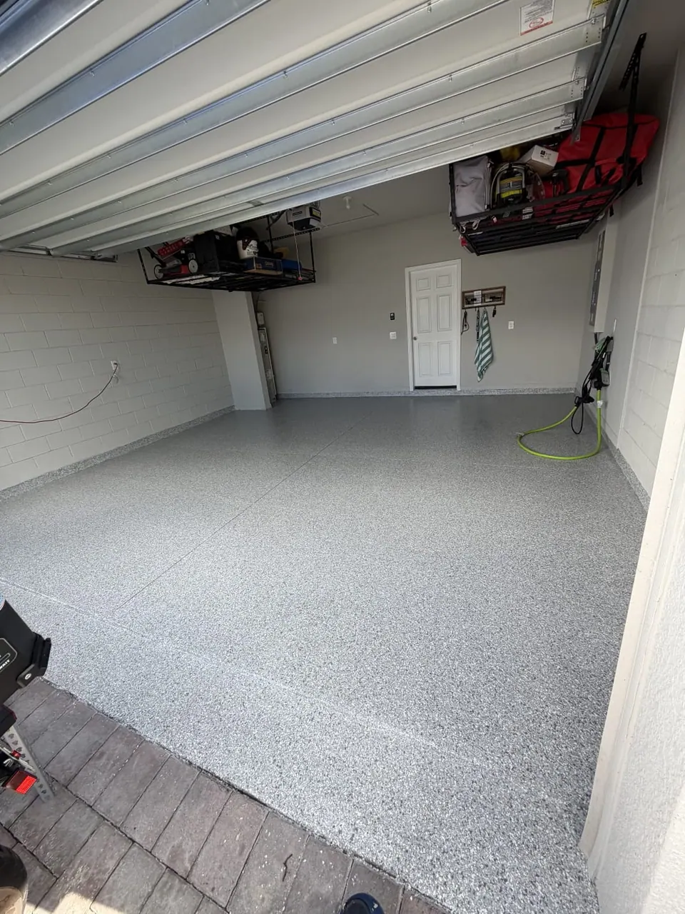 Gray flake coated garage floor with two overhead storage racks