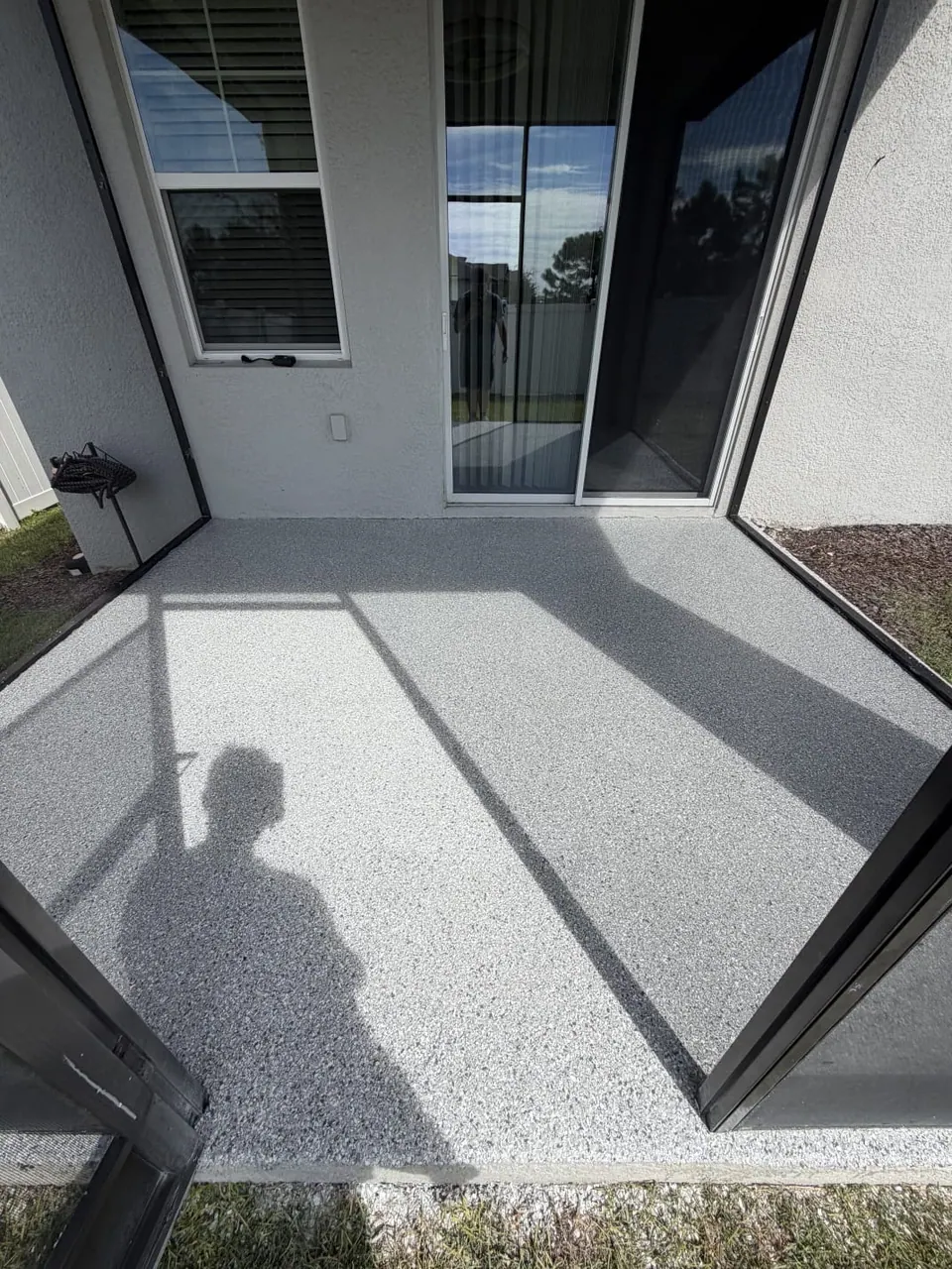 Gray flake floor coating in a screened patio beside sliding glass doors