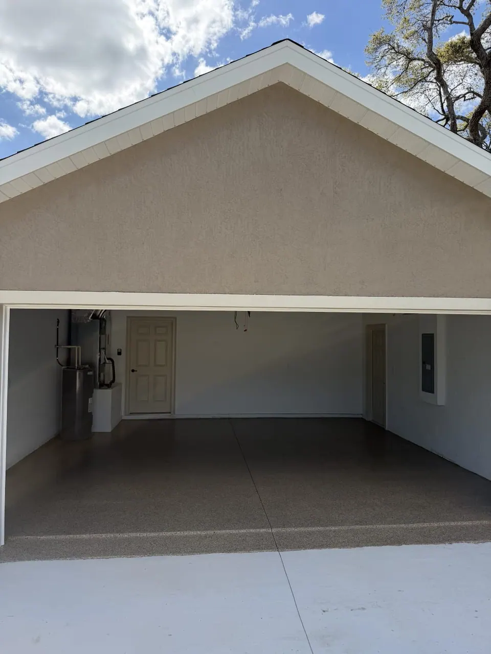 Tan flake floor coating in an open garage viewed from the driveway
